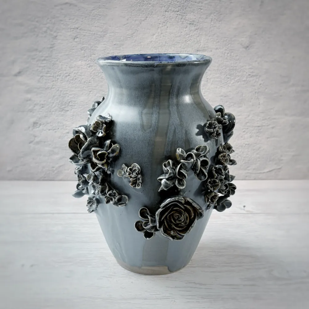 Jarrón con aplicacioenes de flores en azul. Andrea Corpancho Cerámica hecha a mano