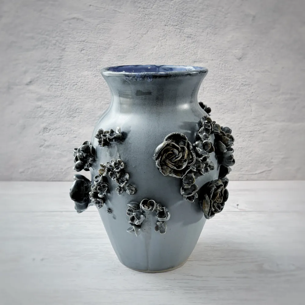 Jarrón con aplicacioenes de flores en azul. Andrea Corpancho Cerámica hecha a mano